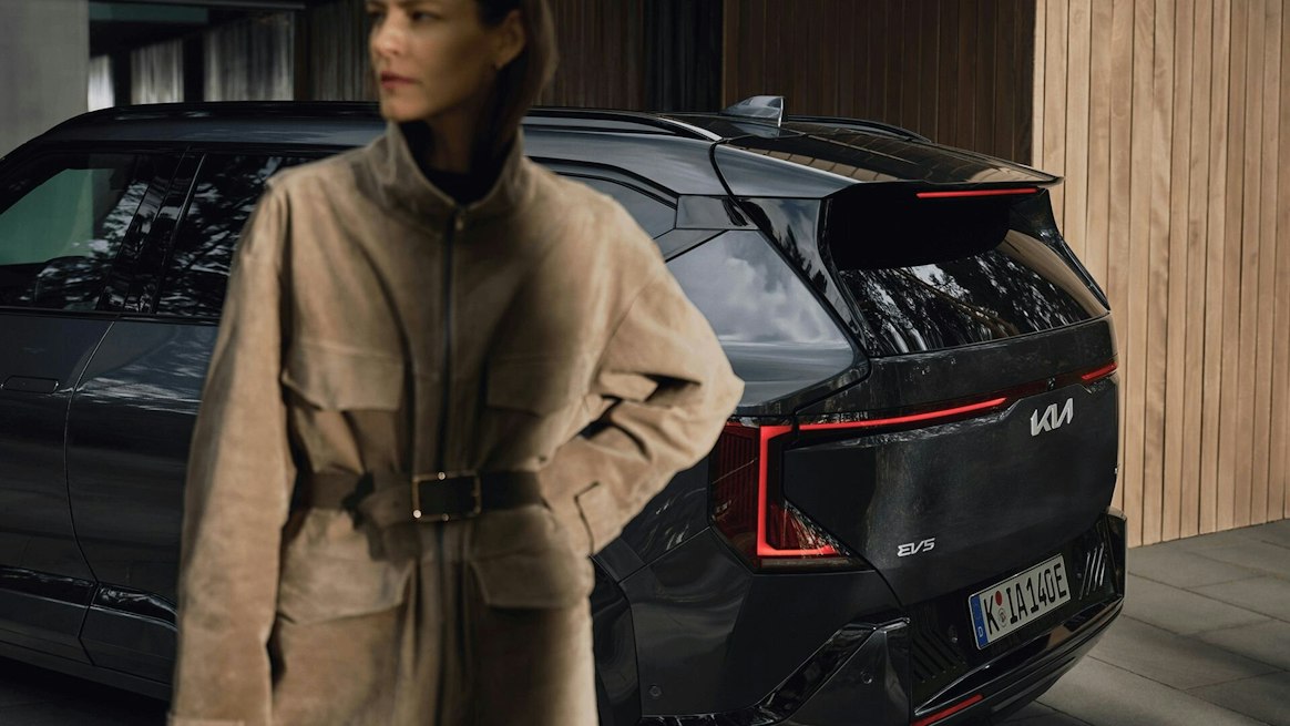 Eine Frau steht vor dem Kia EV5