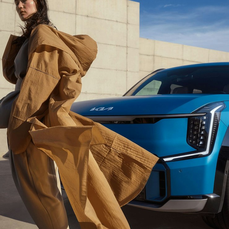 Eine Frau steht vor dem Kia EV9