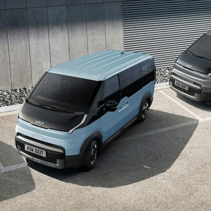 Kia PV5 WAV beim Ausparken mit aktivem Totwinkel-Kollisionsvermeidungsassistenten, der dabei hilft, sich seitlich von hinten nähernde Fahrzeuge zu erkennen.