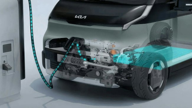 Frontansicht des Kia&nbsp;PV5&nbsp;WAV an einer Ladestation mit eingeblendeter Darstellung des Antriebsstrangs.