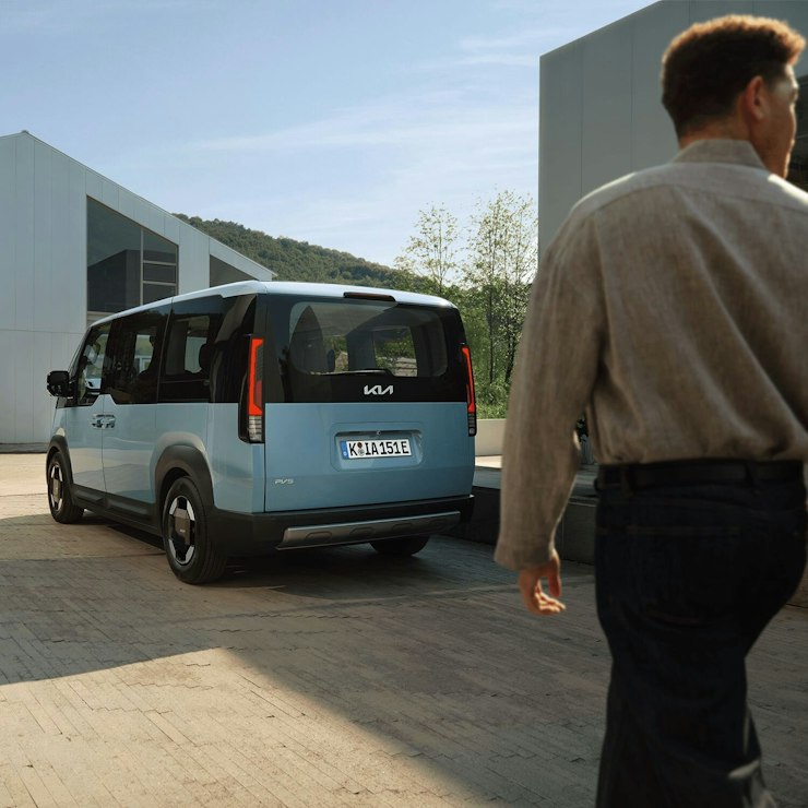 Heckansicht des Kia PV5 Passenger neben einer Ladestation