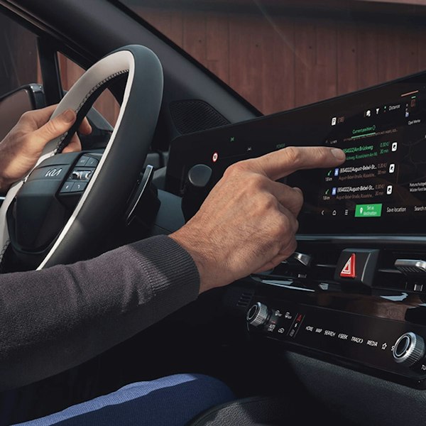 Eine Person bedient den Screen im neuen Kia Sportage