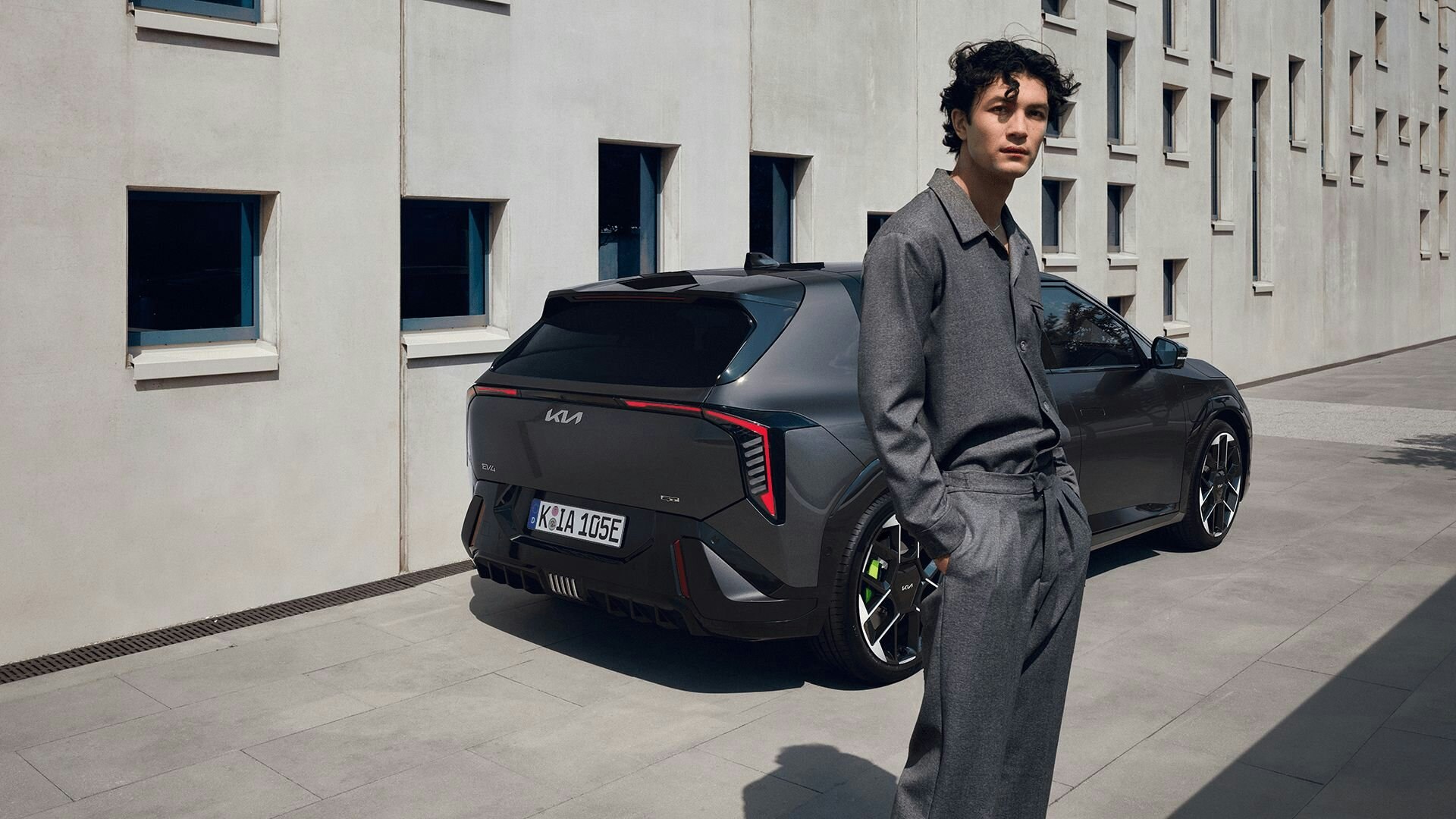 Ein Mann steht vor dem Heck des Kia EV4 GT
