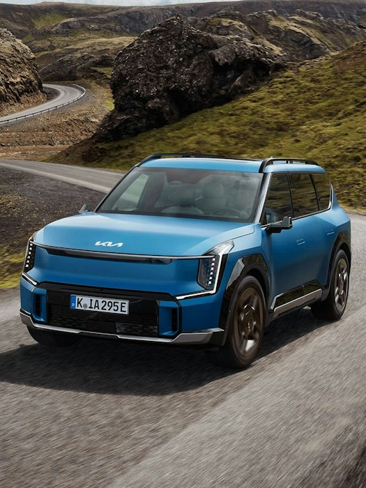Der Kia EV9 fährt auf einer Bergstrasse