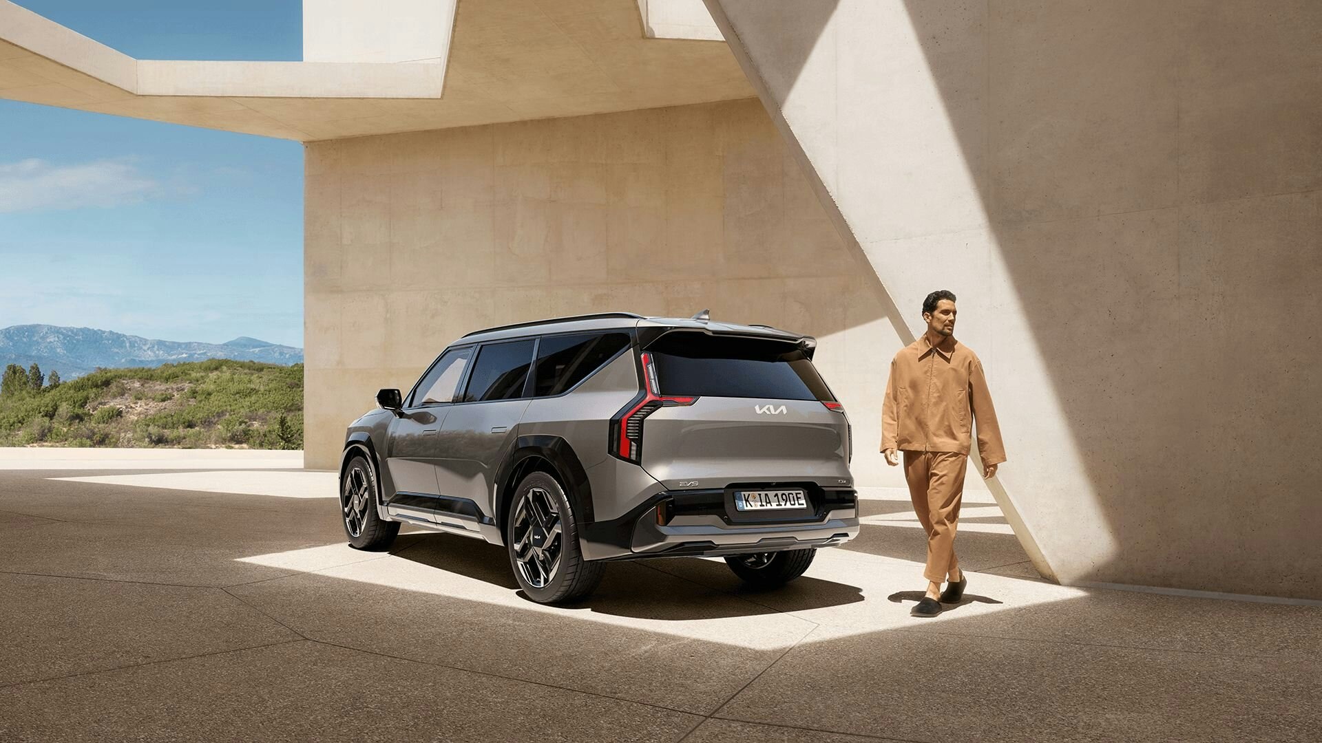 Ein Mann läuft hinter dem Kia EV9 GT durch