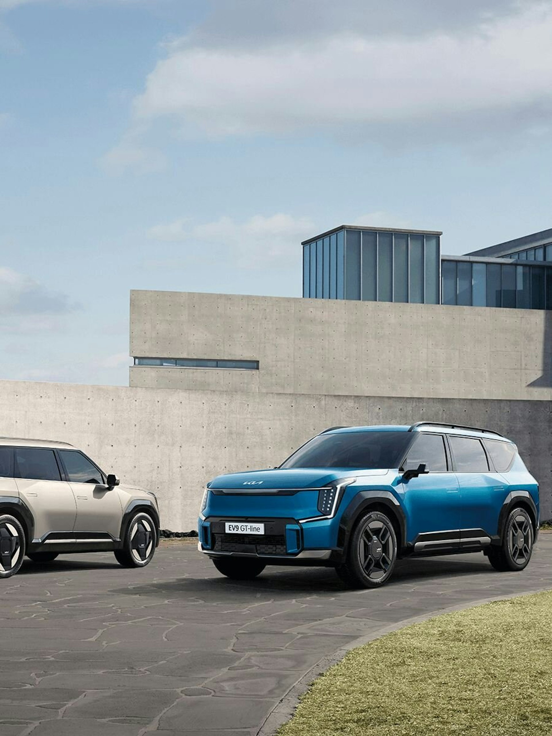 Zwei Kia EV9 stehen bei einem Gebäude