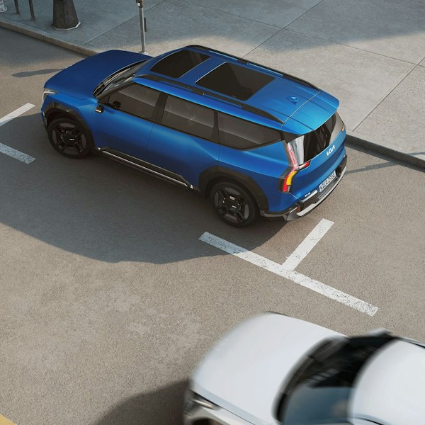 Eine Auto fährt am parkierten Kia EV9 vorbei