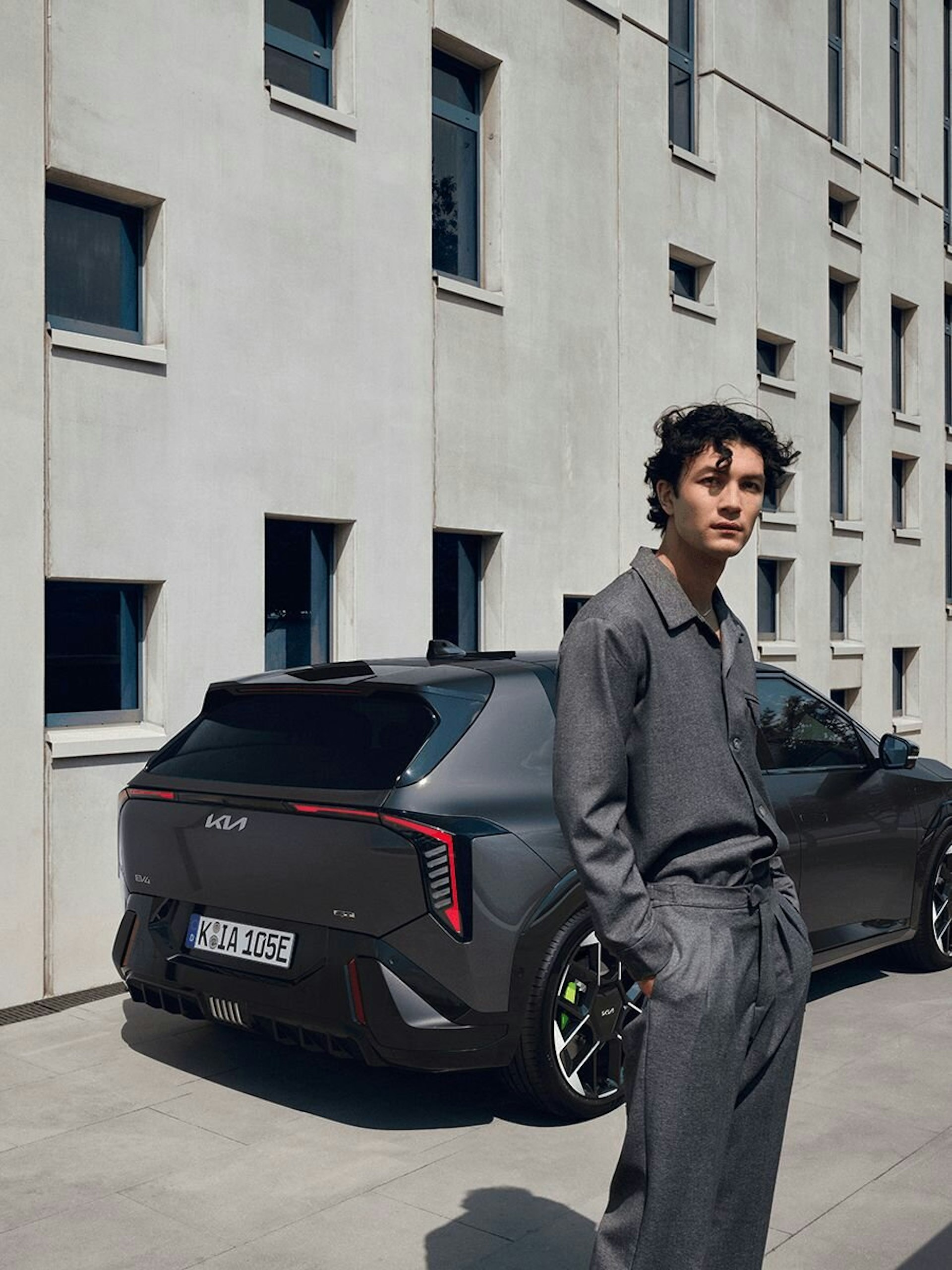 Ein Mann steht vor dem Heck des Kia EV4 GT