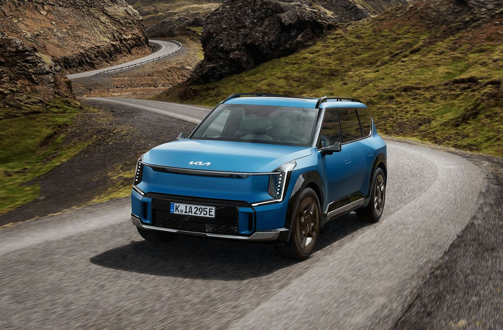 Der Kia EV9 fährt auf einer Bergstrasse