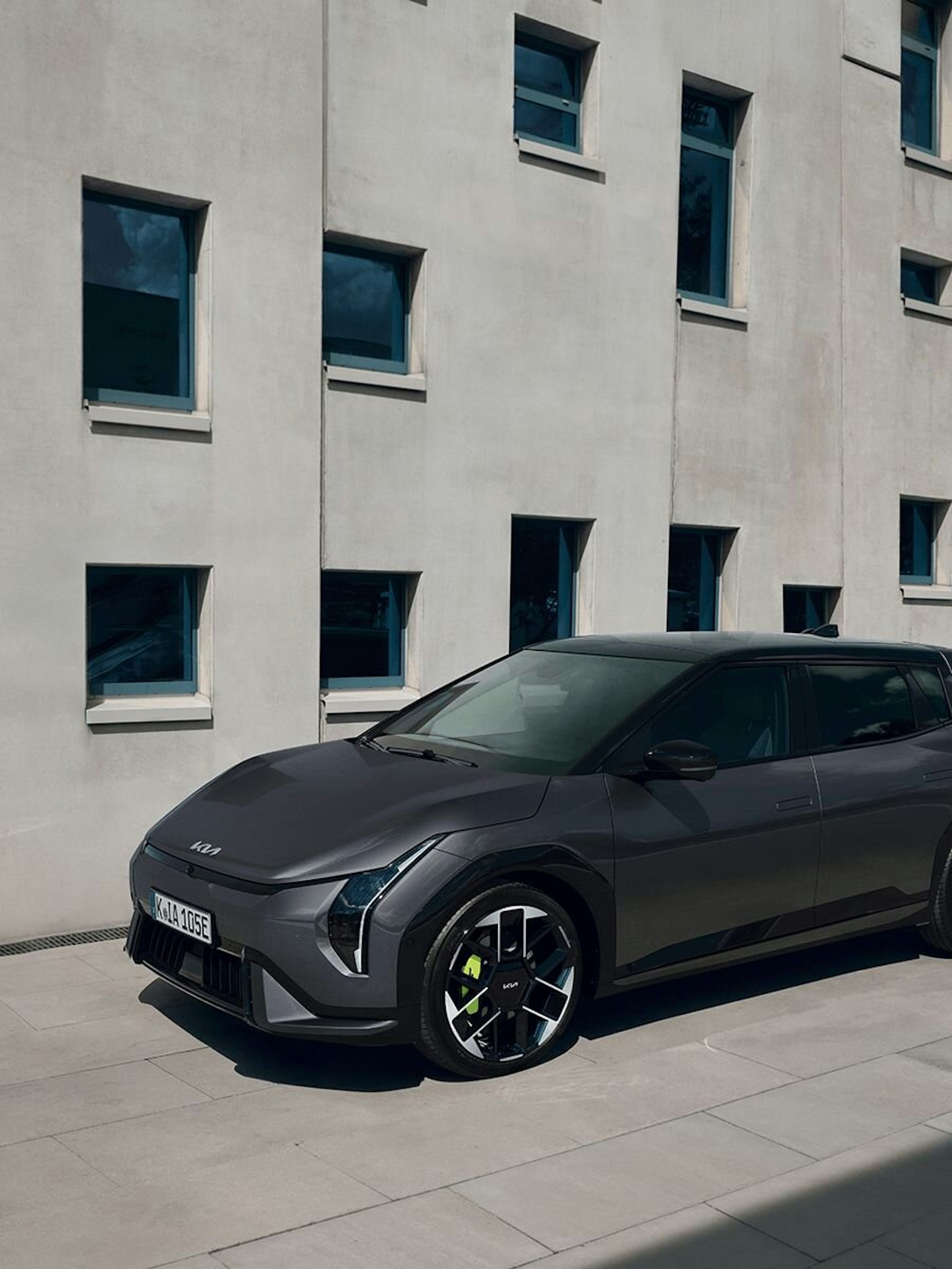 Ein Mann steht neben einem grauen Kia EV4 GT