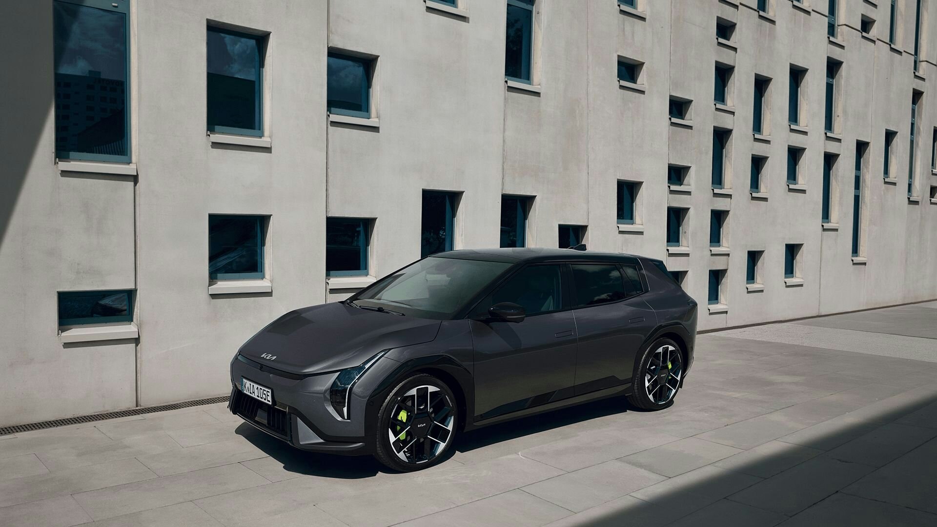 Ein Mann steht neben einem grauen Kia EV4 GT